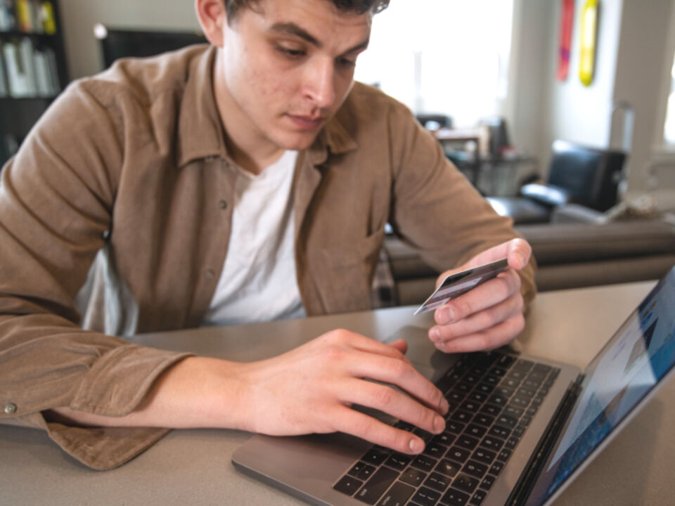 Someone paying by card at a laptop