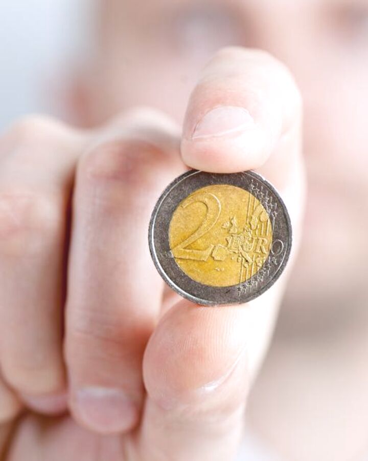A hand holding a coin