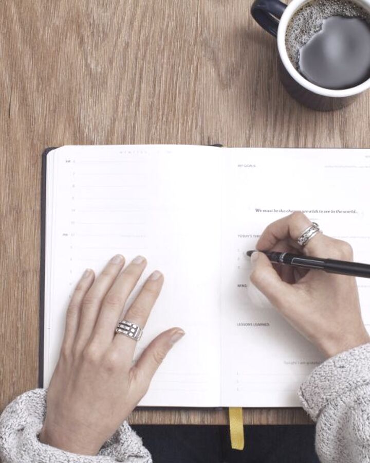 Someone writing plans in a notebook